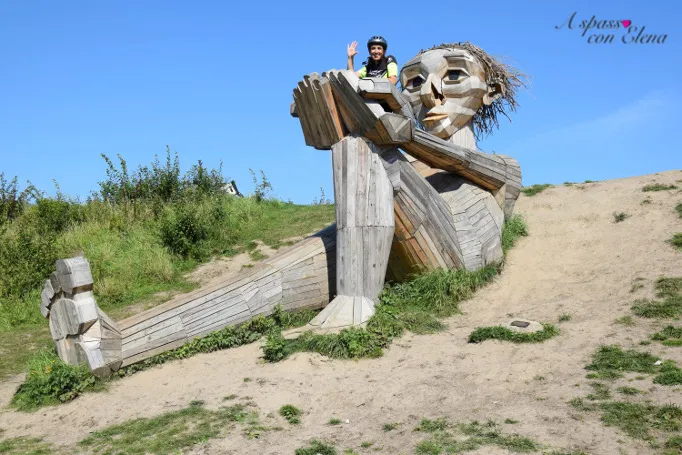 Persona saluta dalla scultura di legno di un gigante nascosto su una collina