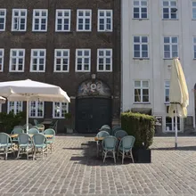 Tavolini e sedie di un caffe su pavimentazione in ciottoli