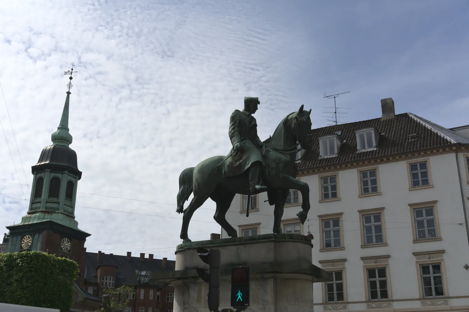 Statua equestre in bronzo davanti a un campanile e palazzi