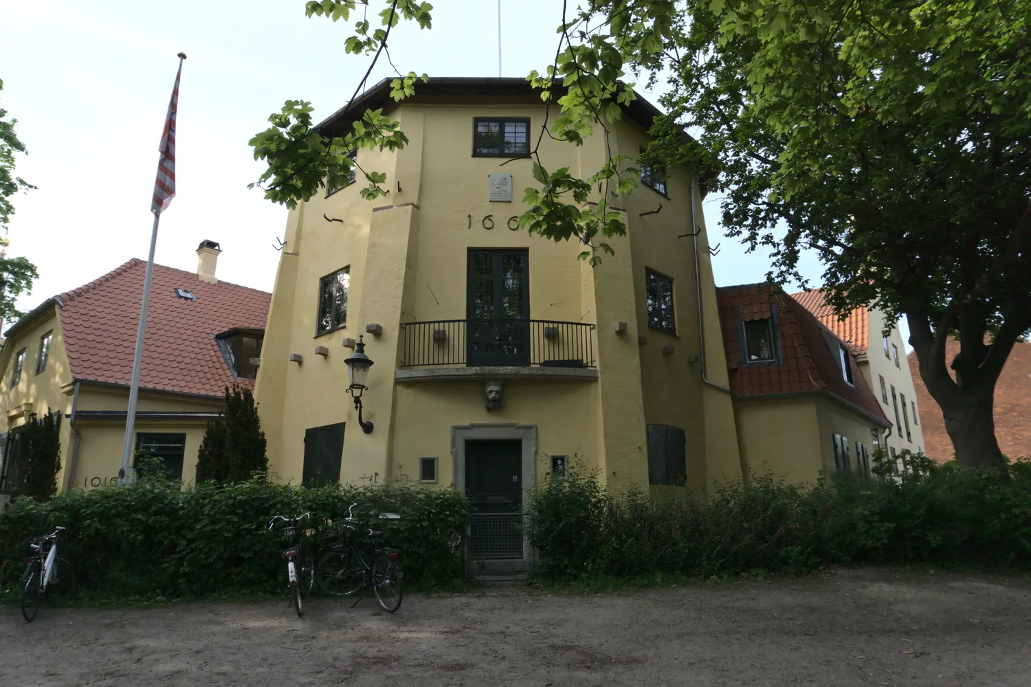 Casa gialla a tre piani con bandiera danese e biciclette davanti a Christianshavn