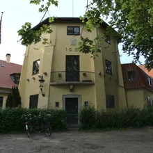 Casa gialla a tre piani con bandiera danese e biciclette davanti a Christianshavn