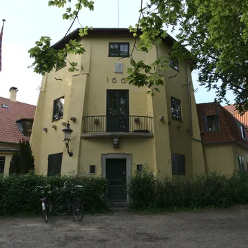 Casa gialla a tre piani con bandiera danese e biciclette davanti a Christianshavn