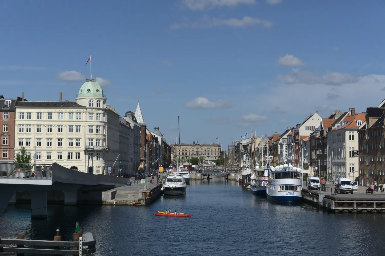 Veduta di un canale di Copenaghen con barche, kayak rosso e palazzi storici
