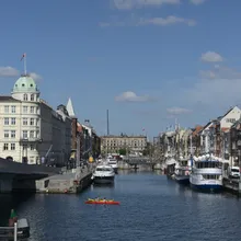 Veduta di un canale di Copenaghen con barche, kayak rosso e palazzi storici