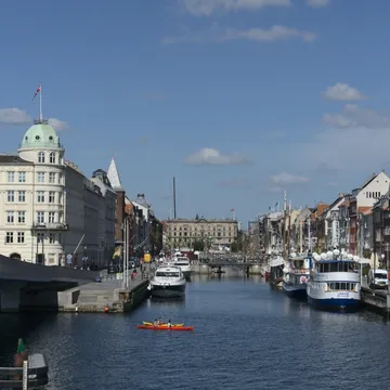 Veduta di un canale di Copenaghen con barche, kayak rosso e palazzi storici