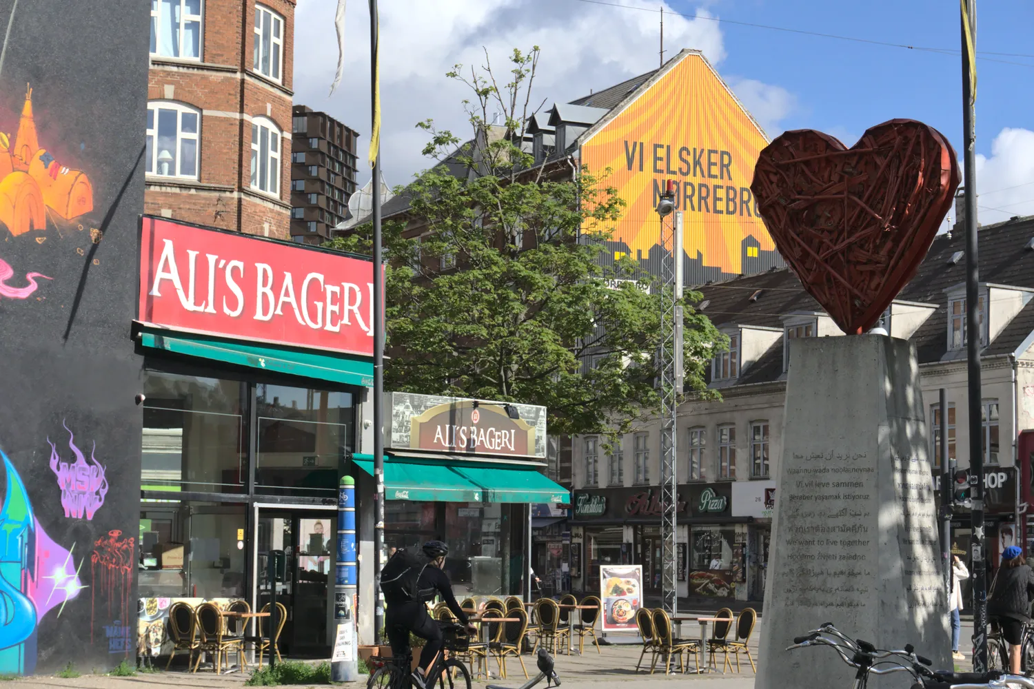 Piazza di Nørrebro con panetteria, murale arancione e scultura a cuore rosso