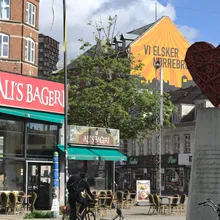 Piazza di Nørrebro con panetteria, murale arancione e scultura a cuore rosso