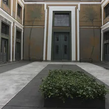 Cortile interno con murali di palme e una siepe verde squadrata