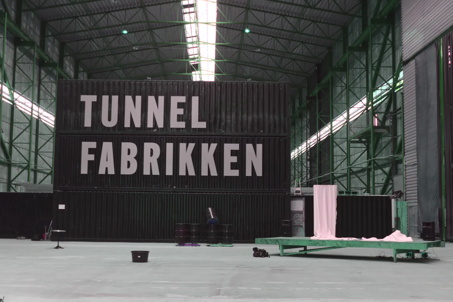 Capannone industriale con grande scritta Tunnel Fabrikken su container neri