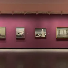 Quattro dipinti surrealisti incorniciati su parete magenta al Louisiana Museum of Modern Art