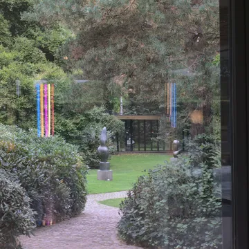 Giardino con sculture del Louisiana Museum visto attraverso una vetrata riflettente