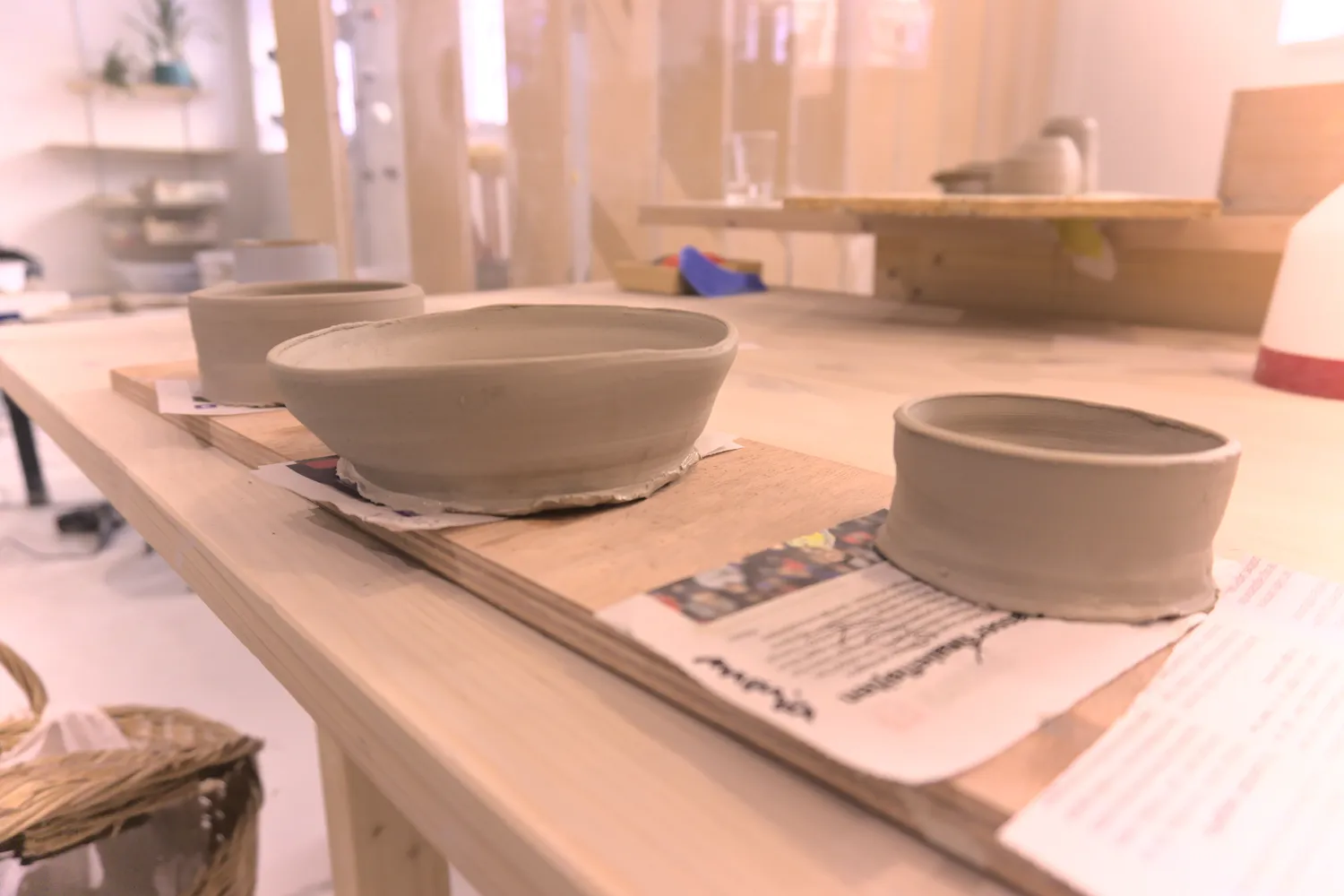 Ciotole di argilla grigia non cotta su tavole di legno in uno studio di ceramica