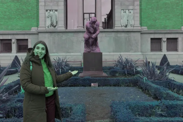 Guida indica la scultura del Pensatore nel giardino di un museo