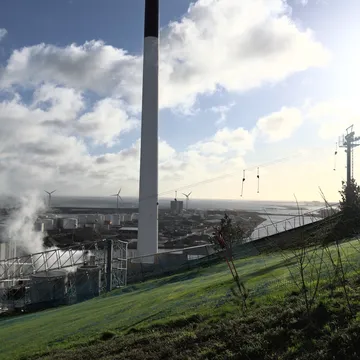 Camino e impianto del termovalorizzatore Amager Bakke visti da un pendio erboso sul mare