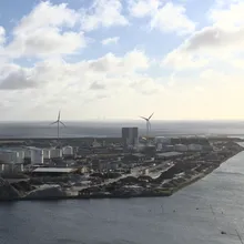 Veduta del porto industriale di Refshaleøen con turbine eoliche e ponte sullo sfondo