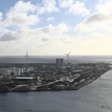 Veduta del porto industriale di Refshaleøen con turbine eoliche e ponte sullo sfondo