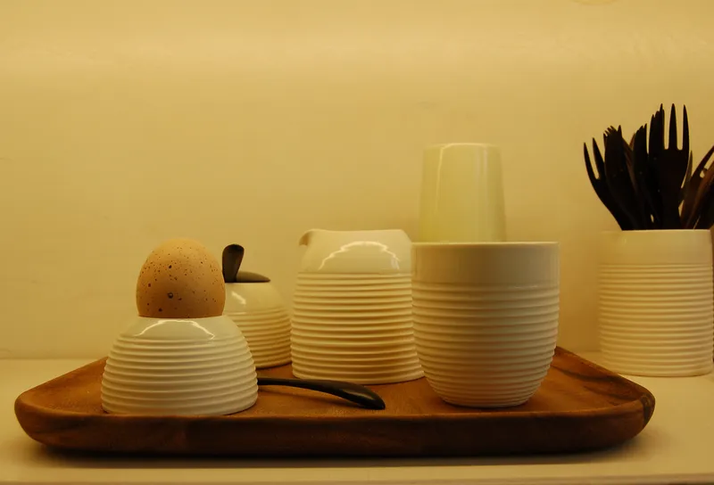 Stoviglie bianche rigate e uovo su vassoio di legno, collezione Colazione di WAUW design