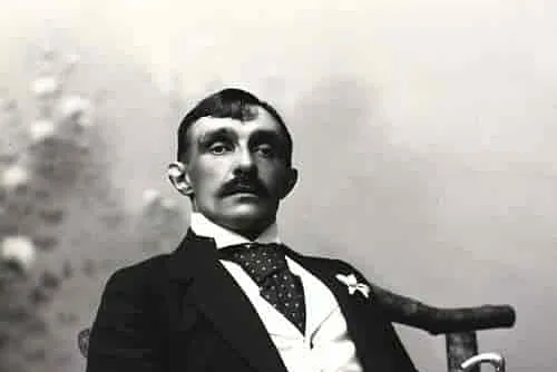Ritratto in bianco e nero di un uomo elegante con baffi seduto