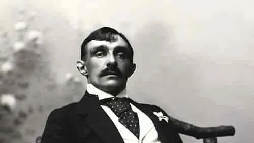Ritratto in bianco e nero di un uomo elegante con baffi seduto