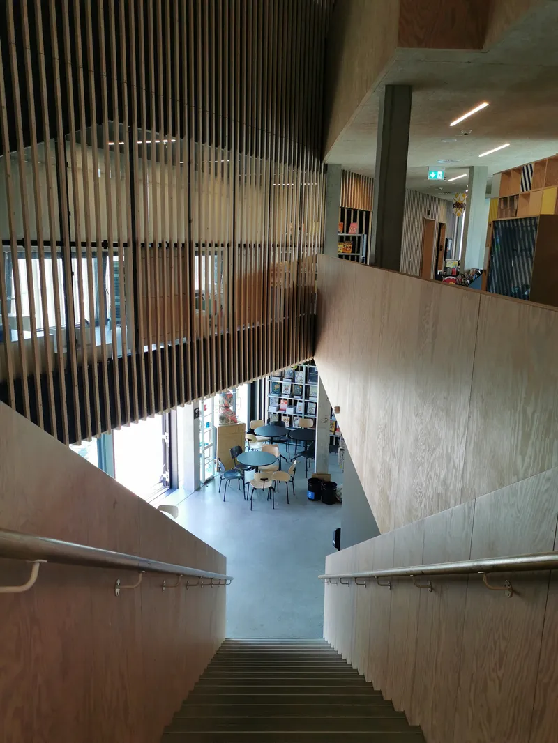 Scalinata della biblioteca Tingbjerg che scende verso la caffetteria in legno