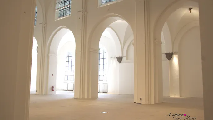 Sala espositiva bianca della kunsthal con archi a volta e alte finestre