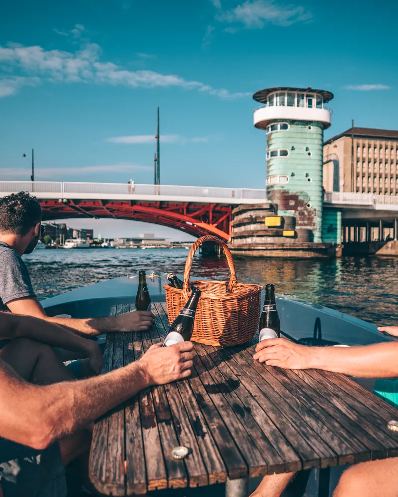 Persone su una barca con cestino da picnic nel canale di Copenaghen