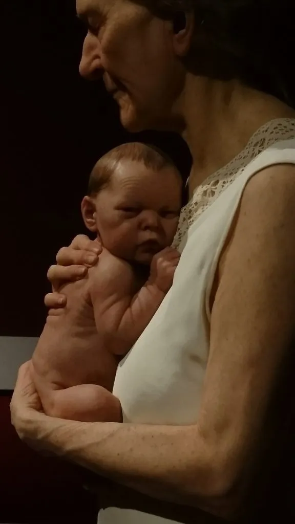 Woman and child di Sam Jinks: scultura iperrealistica di un'anziana che tiene un neonato