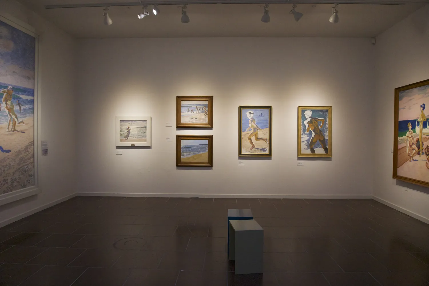 Parete del Willumsens Museum con dipinti di figure su spiaggia illuminata