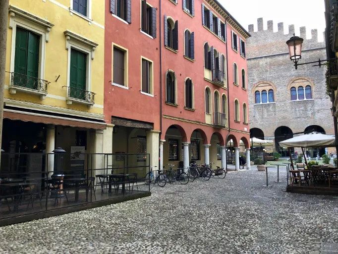 Colourful arcaded buildings and bicycles in a cobbled square in Treviso