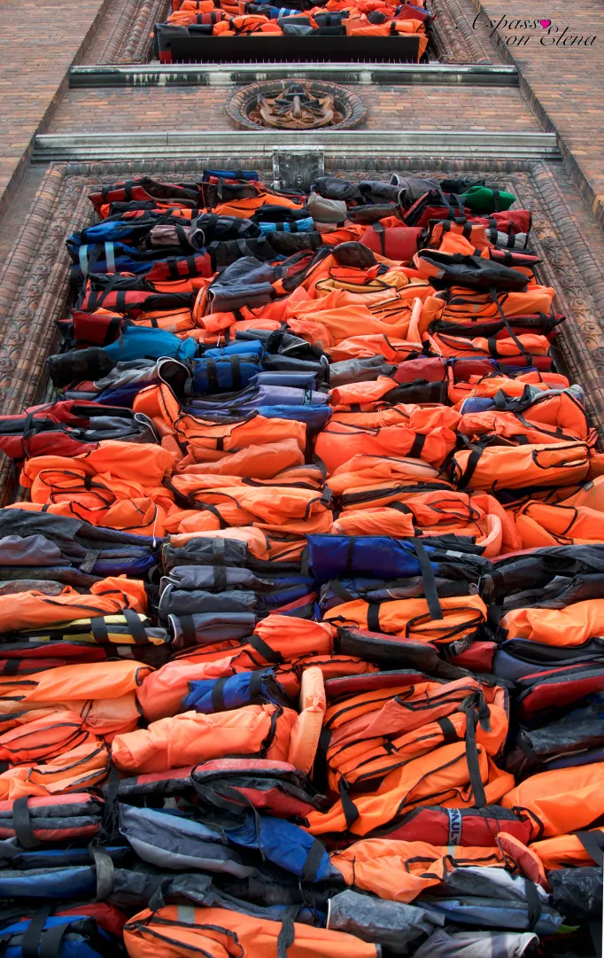 Giubbotti di salvataggio arancioni accatastati, installazione di Ai Weiwei sulla facciata della chiesa Nikolaj