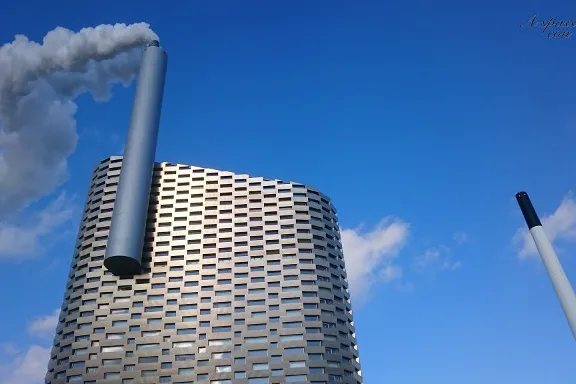 Inceneritore CopenHill con ciminiera fumante contro il cielo azzurro
