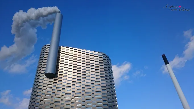 Inceneritore CopenHill con ciminiera fumante contro il cielo azzurro