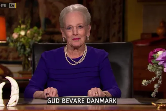 La regina Margrethe II in abito viola con perle, scritta Gud Bevare Danmark