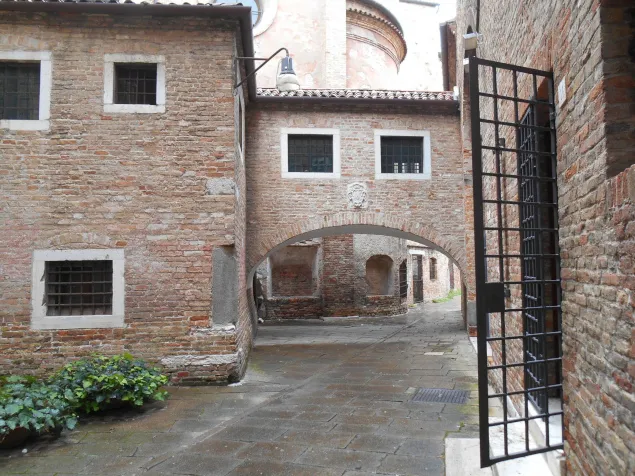 Brick courtyard with an arch and iron gate in Treviso