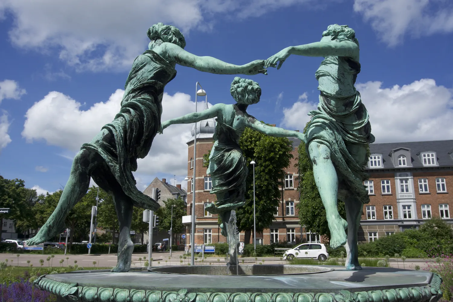 Fontana con tre figure femminili bronzee danzanti davanti a palazzi a Helsingør
