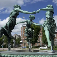 Fontana con tre figure femminili bronzee danzanti davanti a palazzi a Helsingør