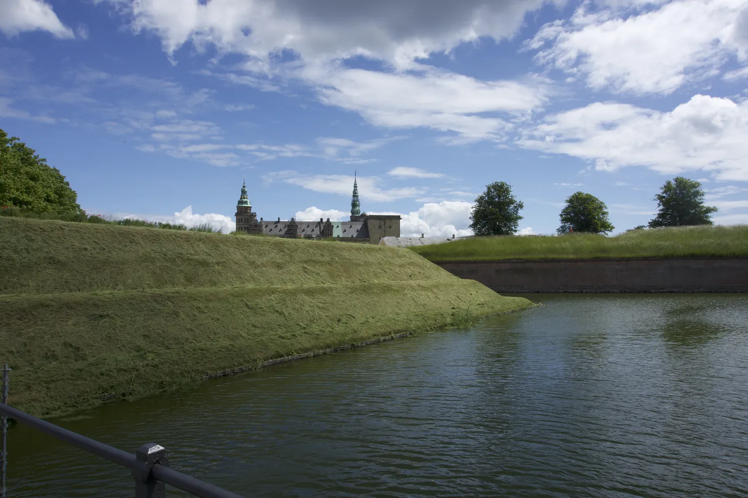 Il Castello di Kronborg con torri verdi oltre il fossato e gli argini erbosi