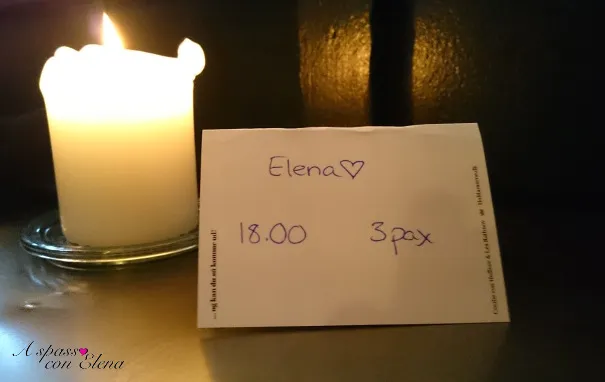 Candela accesa accanto a un biglietto scritto a mano: hygge danese