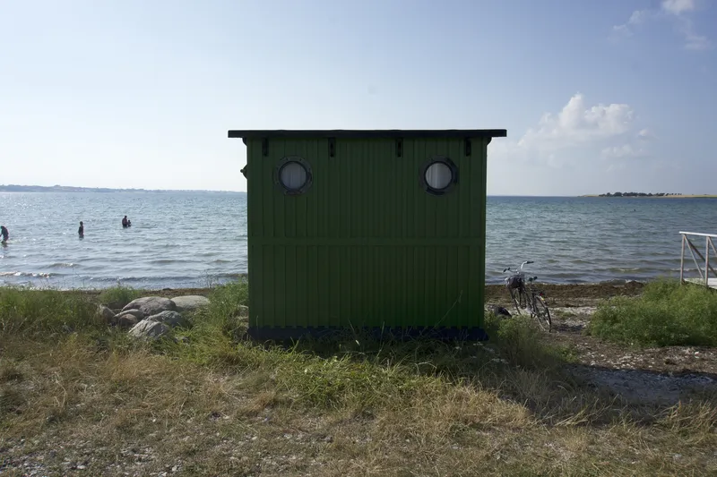 Badehus verde con finestre rotonde sulla spiaggia di Ærø
