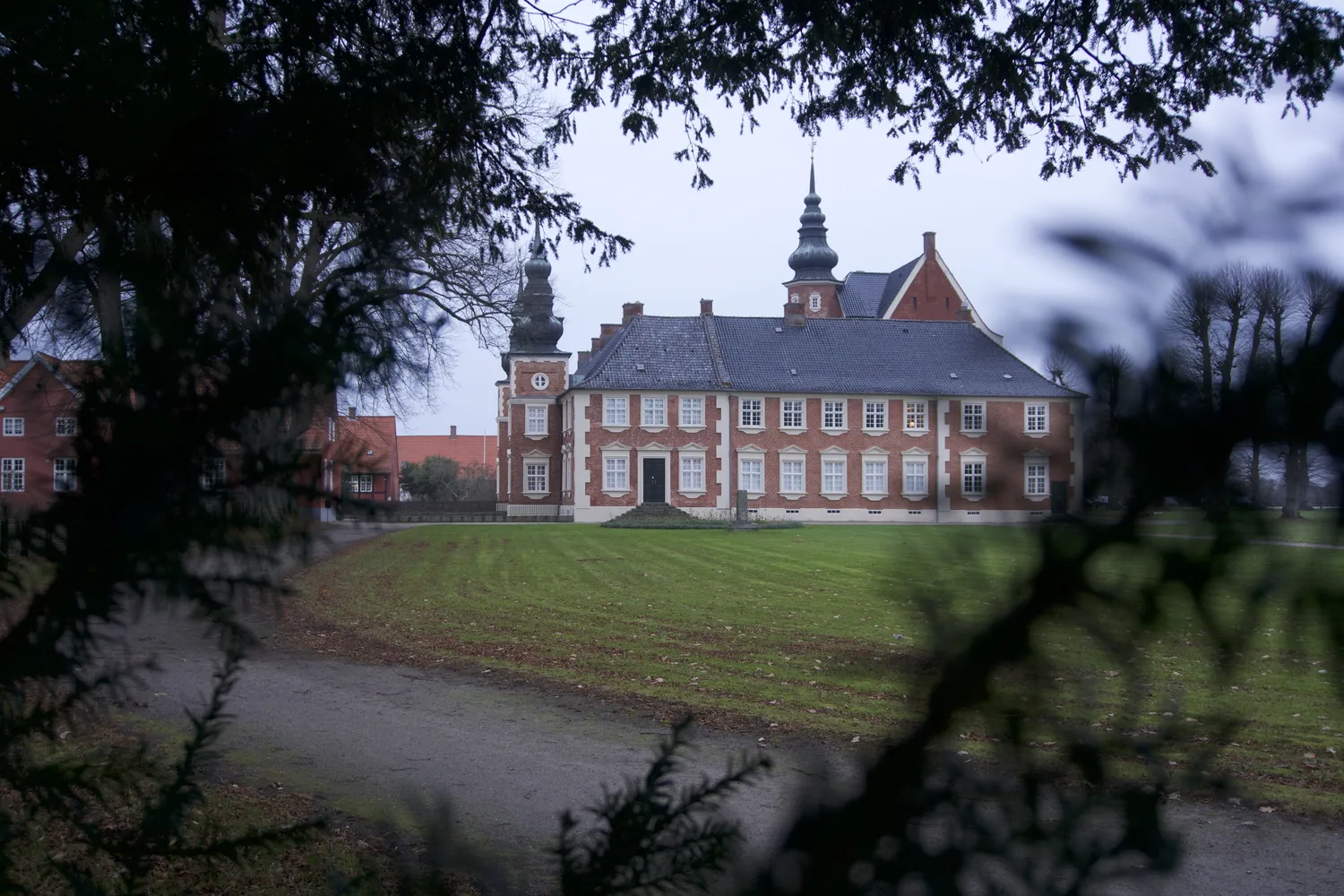 Il castello di Jægerspris in mattoni rossi con torrette tra i rami