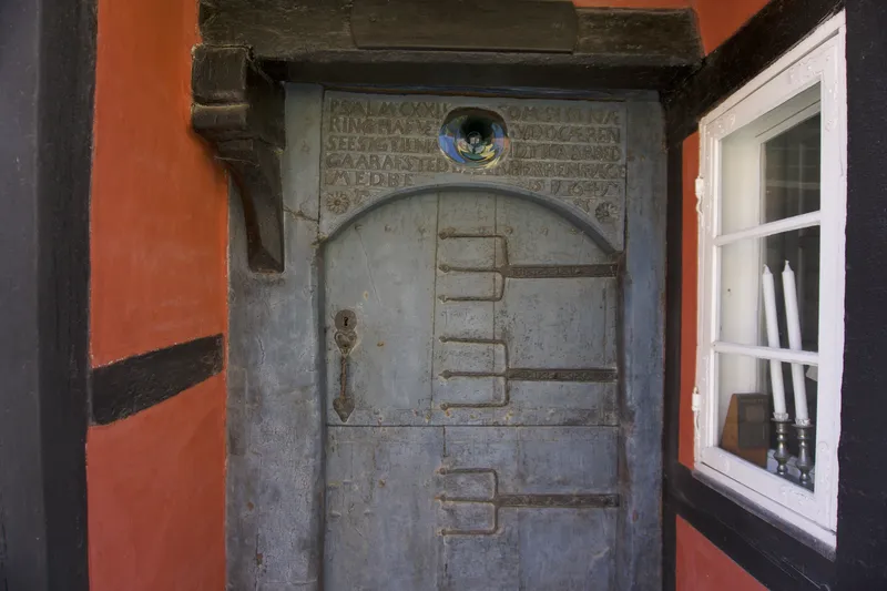 Antica porta in legno grigio con iscrizione sulla casa di Philip Koch a Ærøskøbing
