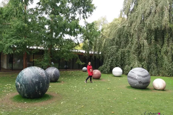 Sculture di sfere di marmo nel parco del Museo Louisiana tra gli alberi