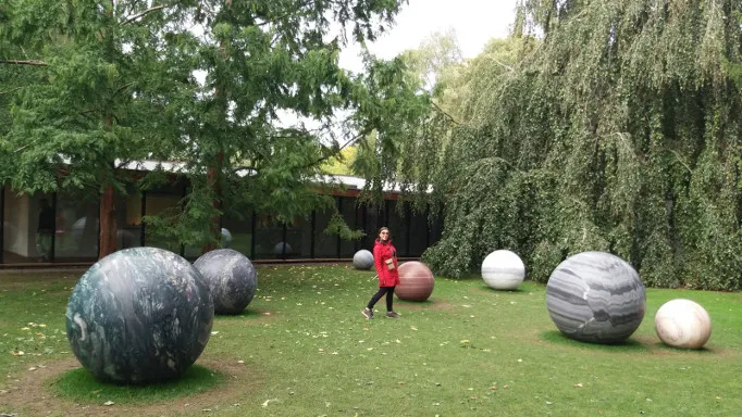 Sculture di sfere di marmo nel parco del Museo Louisiana tra gli alberi