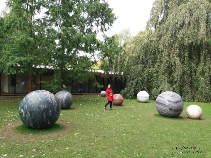 Sculture di sfere di marmo nel parco del Museo Louisiana tra gli alberi
