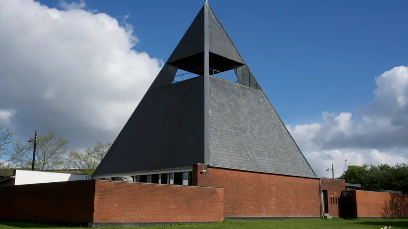 Chiesa piramidale di Holger Jensen con tetto scuro e mattoni rossi