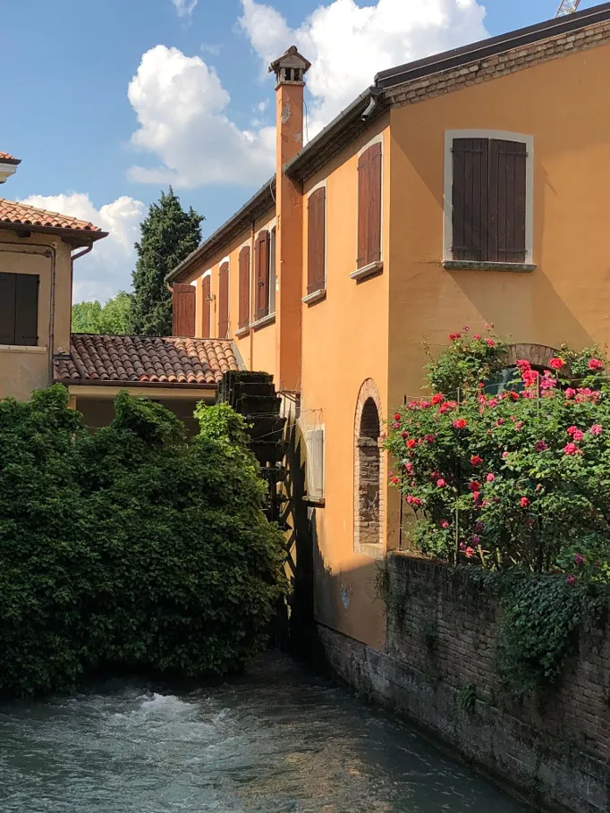 Ochre watermill with water wheel along a Treviso canal