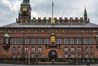 Facciata in mattoni rossi del Municipio di Copenaghen con la torre sotto un cielo grigio