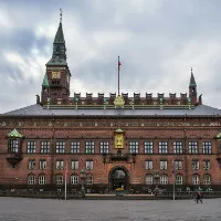 Facciata in mattoni rossi del Municipio di Copenaghen con la torre sotto un cielo grigio