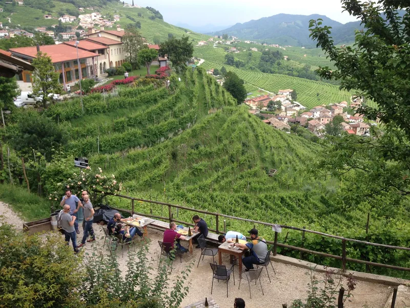Tables at the Osteria senz'Oste overlooking Valdobbiadene's hillside vineyards