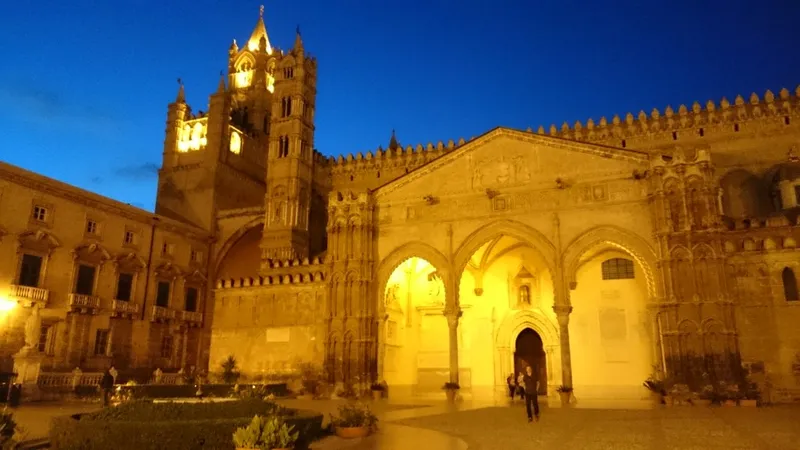Cattedrale di Palermo illuminata all'imbrunire con cielo blu